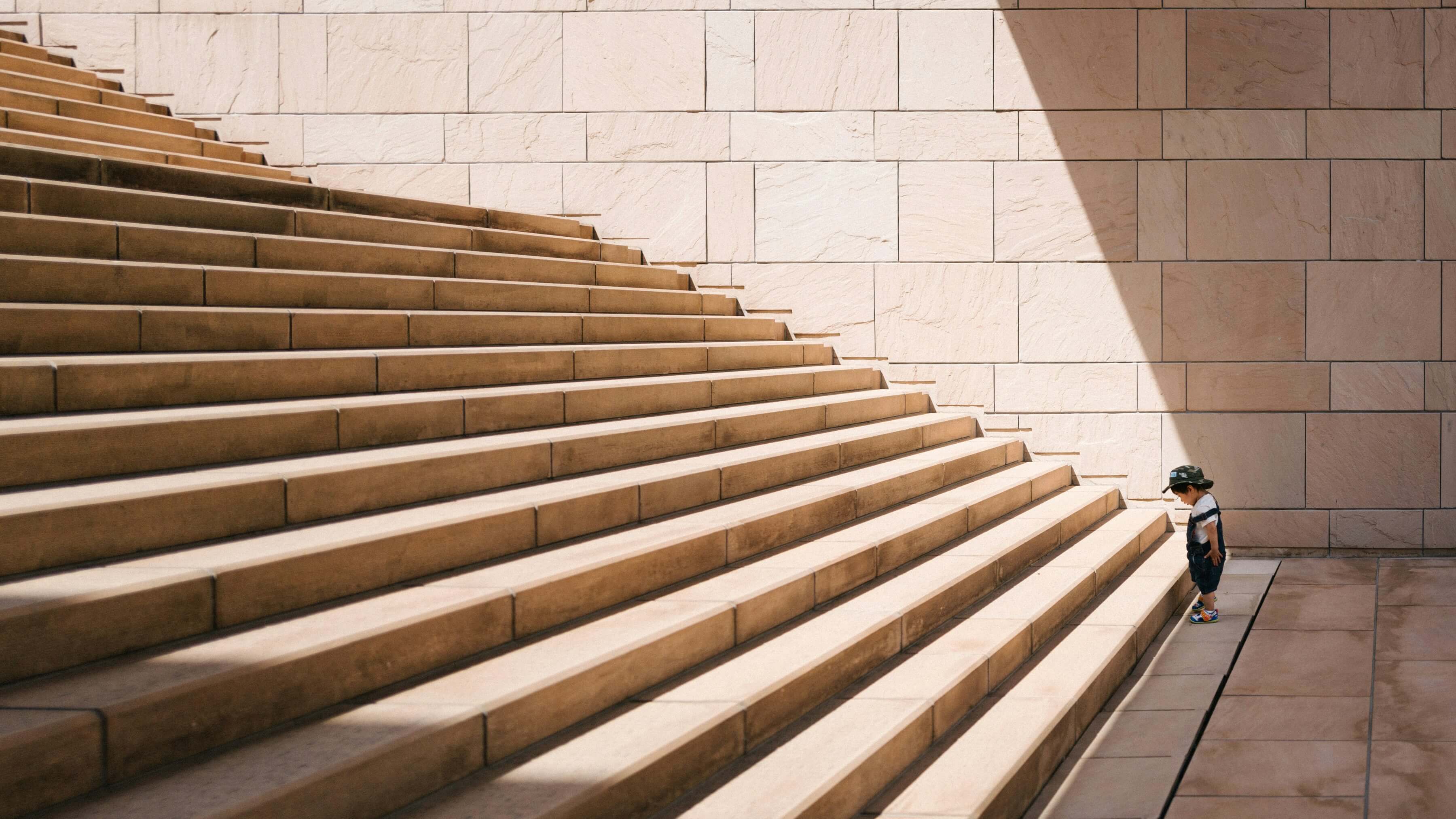Toddlers standing in front of beige concrete stair
